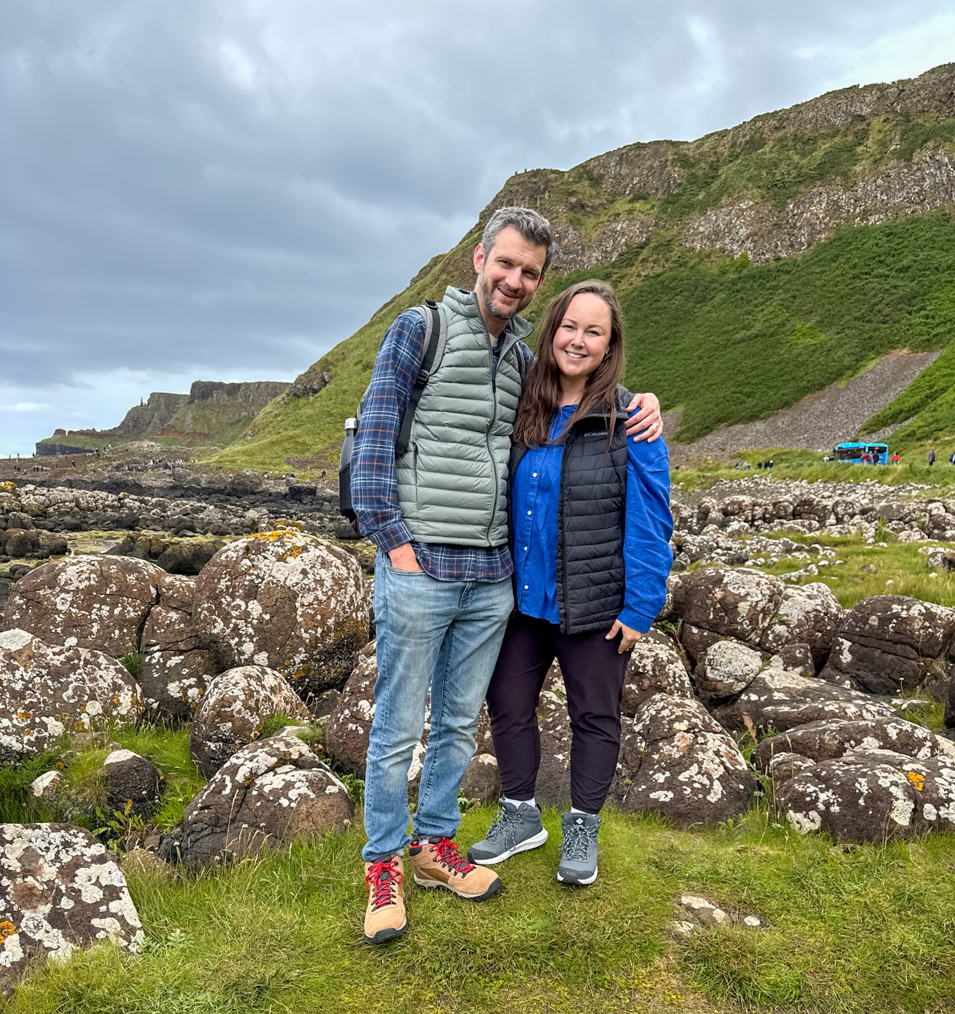 A man and a woman stand together in front of the path that leads to the causeway.