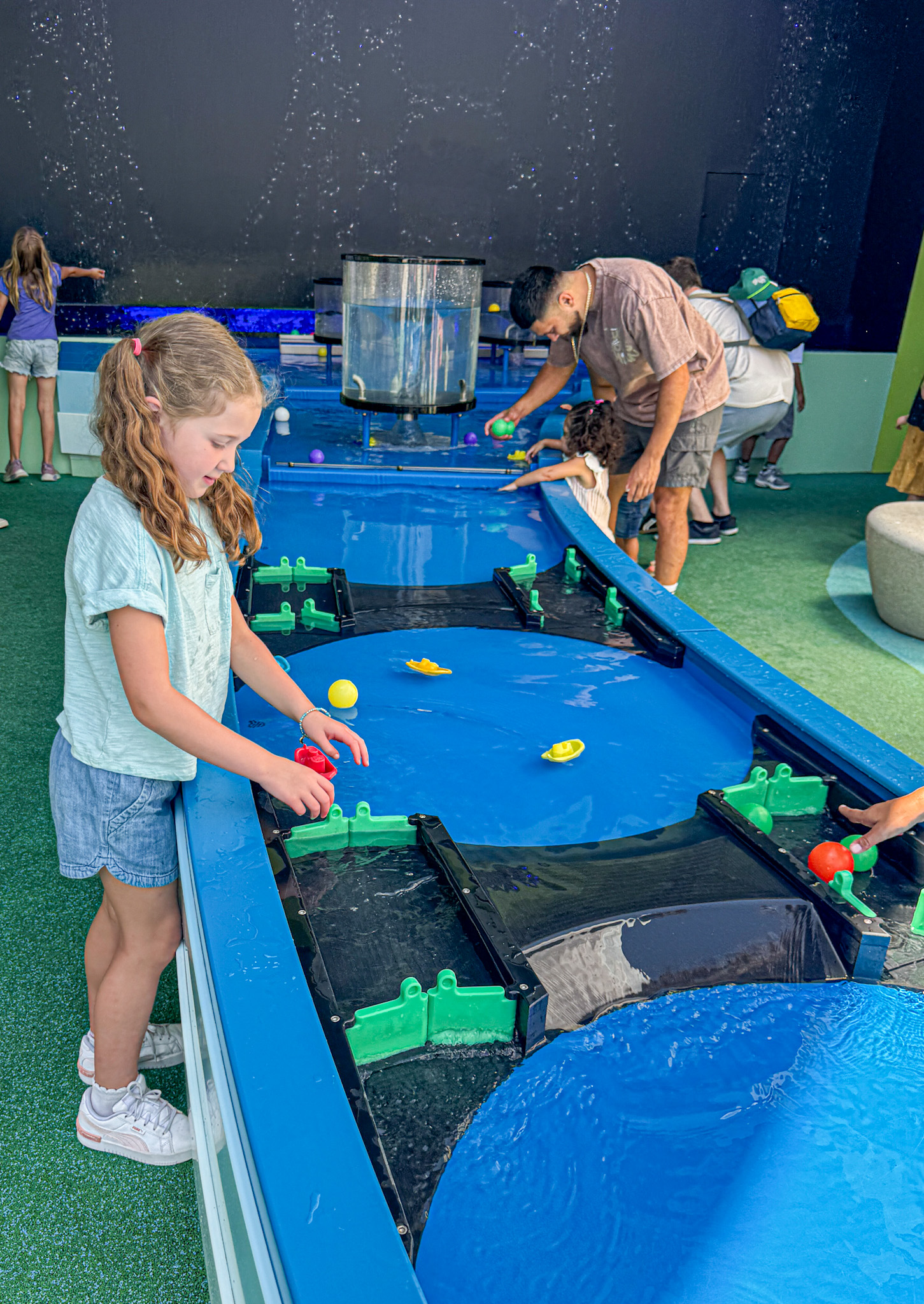 Children playing with floating toys in a water table at an indoor activity center at the Moody Children's Museum at the Perot in Dallas, Texas.