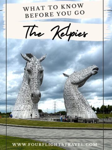 Two large horse-head sculptures, The Kelpies, stand on a cloudy day with people walking nearby.