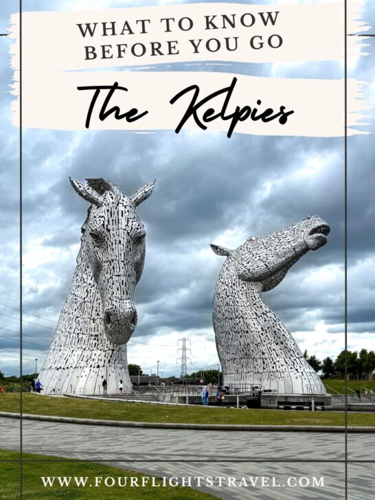 Two large horse-head sculptures, The Kelpies, stand on a cloudy day with people walking nearby.