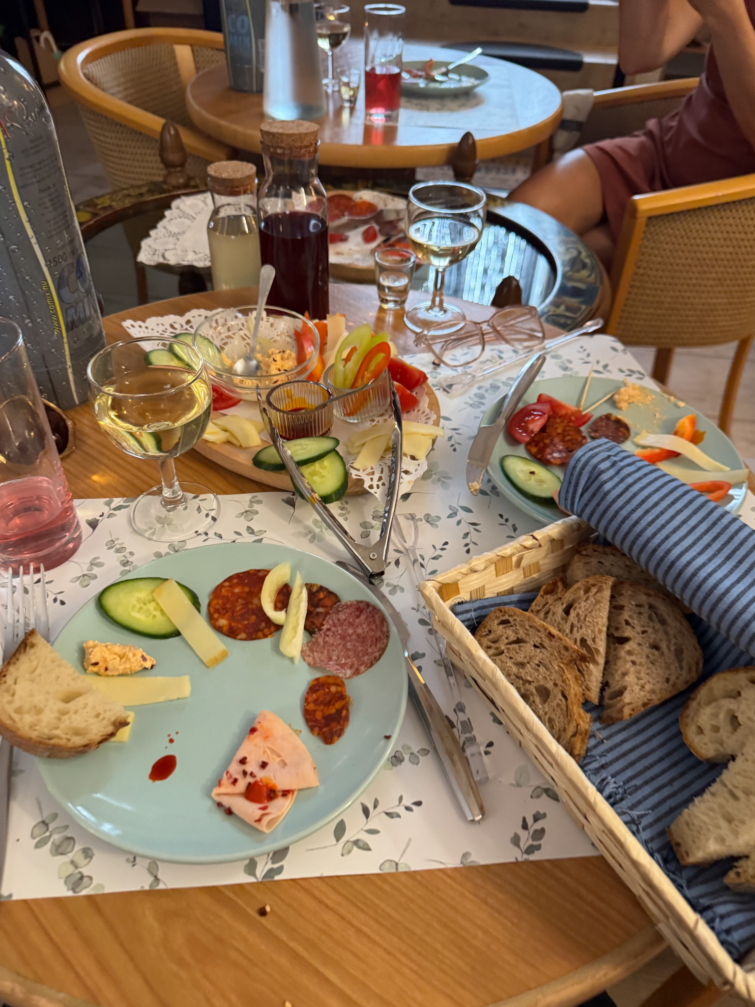A table set with assorted Hungarian bread, meats, cheeses, vegetables, and drinks at a Budapest food tour.