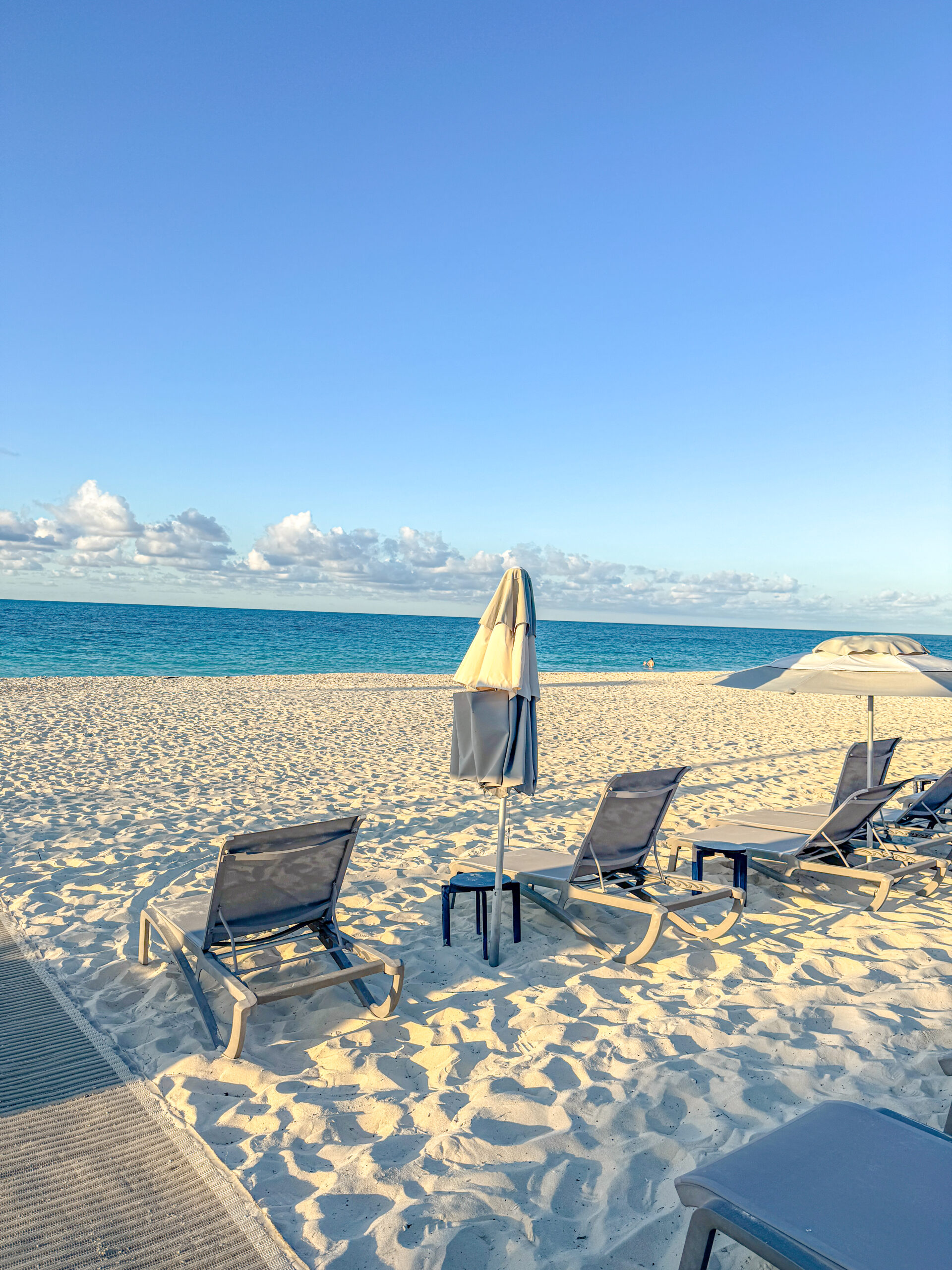 Deck chairs and umbrella on a beach in Bimini Bahamas facing towards the ocean.